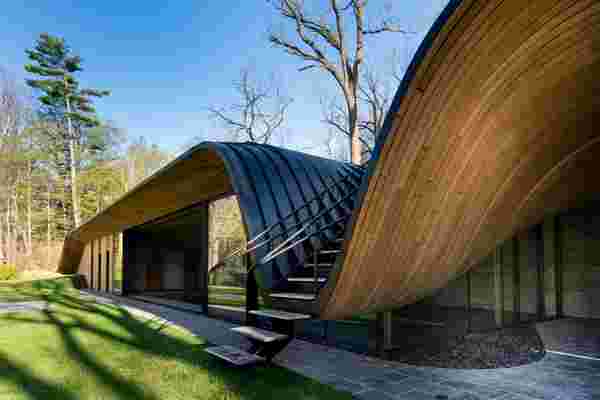 The folds of this fluid structure cradles a staircase & houses a zen pool!